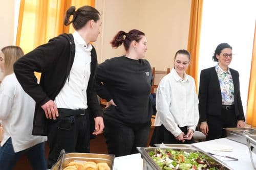 Cseh nap, a Petzeltes tanulók állnak oktatójukkal az ételes fémedények előtt