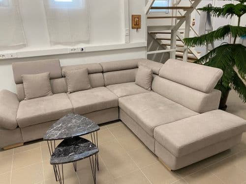 Textil sarokgarnitúra párnákkal, előtte asztal, a DKA földszinten. Háttérben lépcső
