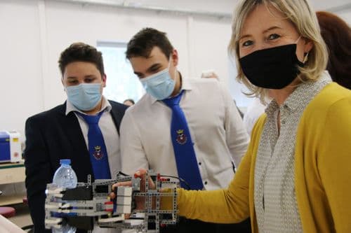 két Boronkay-s tanuló oktatójukkal egy lego robotot szerel